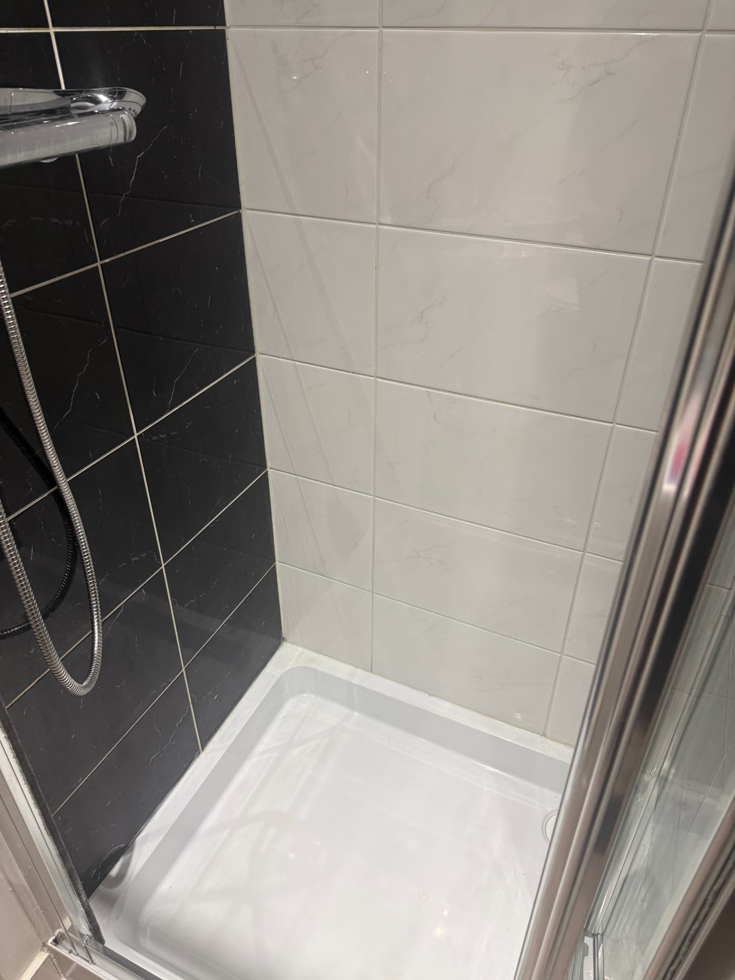 The same shower with clean tiles, bright grout and a spotless tray after cleaning
